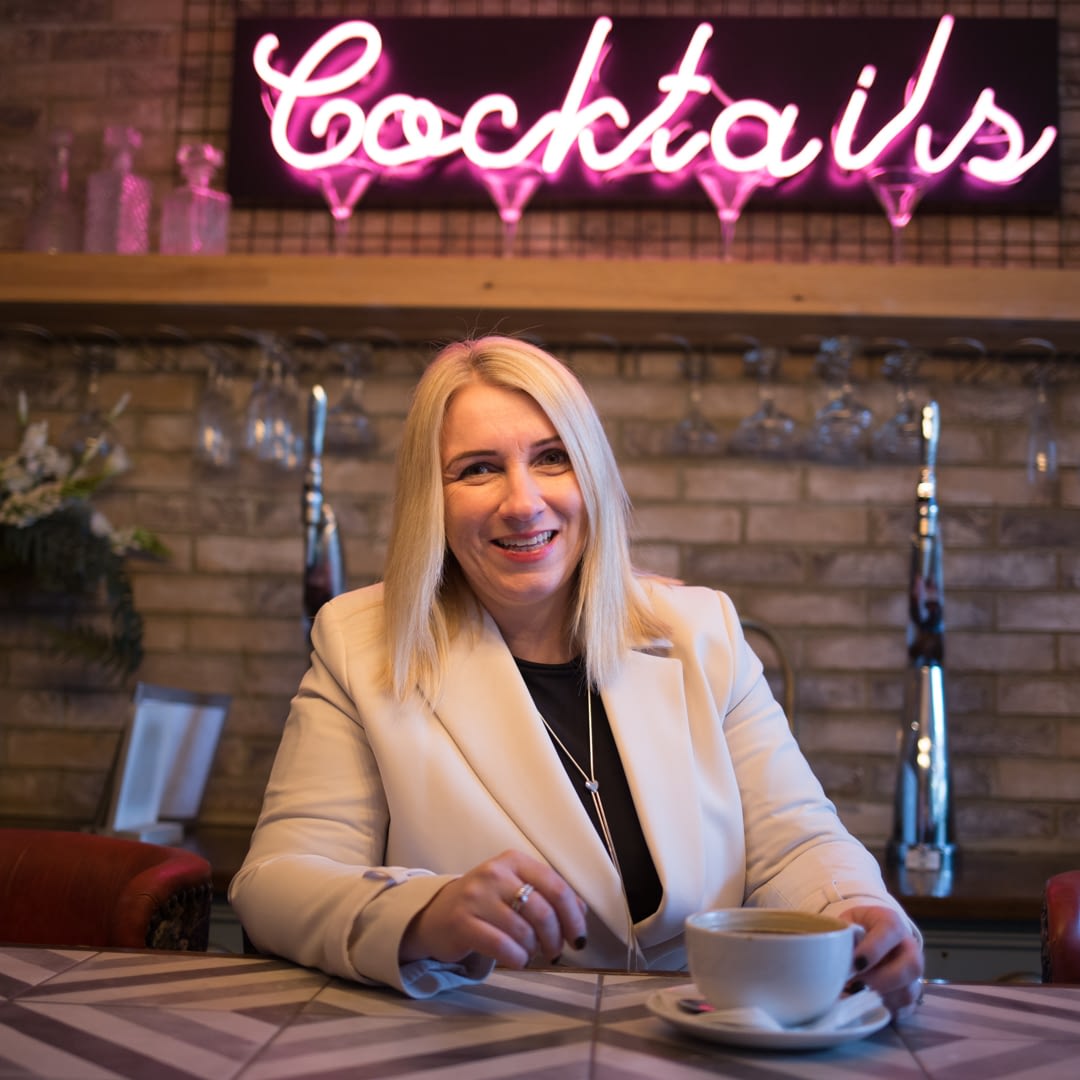 Catherine Tuckwell Personal Brand Photography session in restaurant with neon Cocktails sign