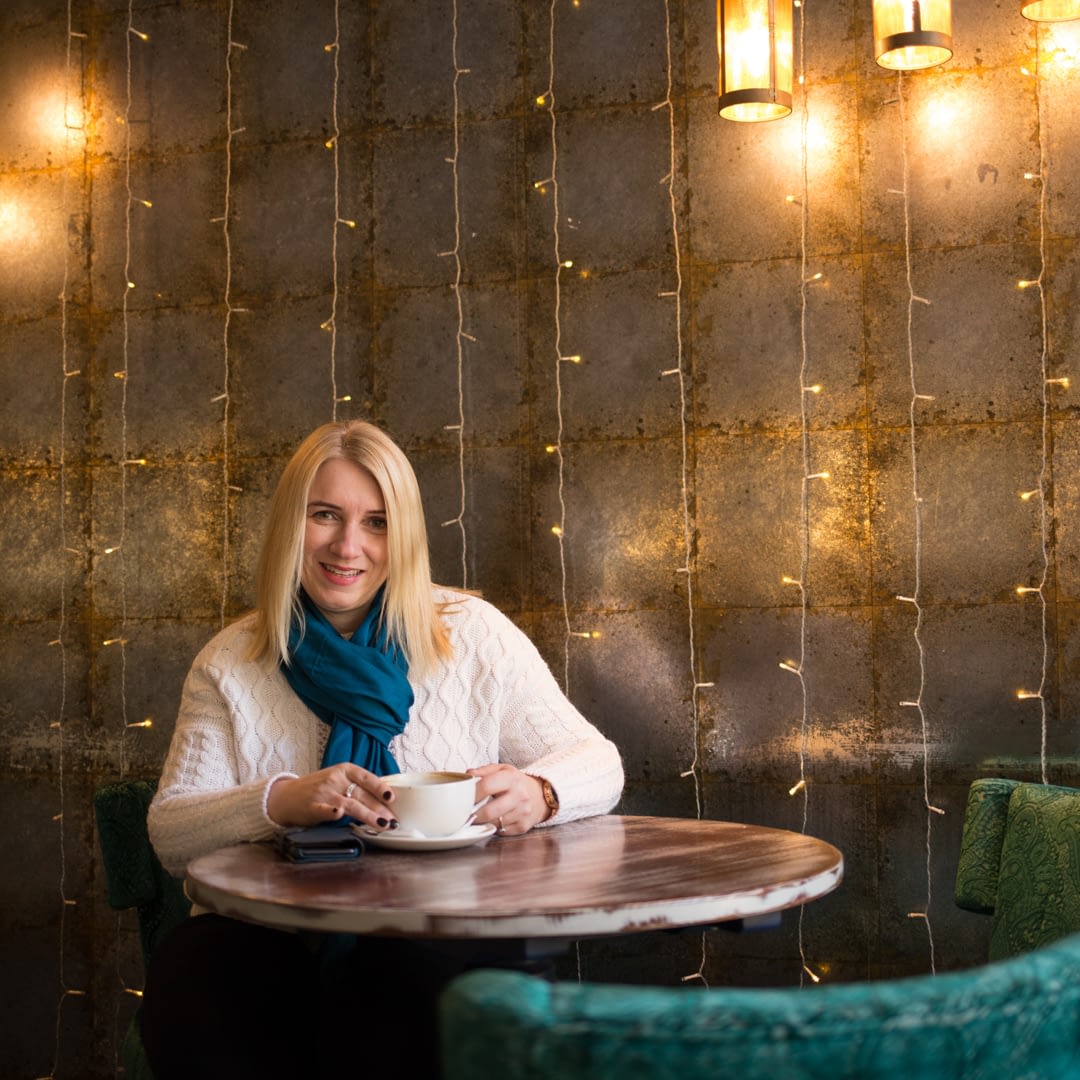 Catherine Tuckwell Personal Brand Photography session in restaurant with green chair and string lights backdrop